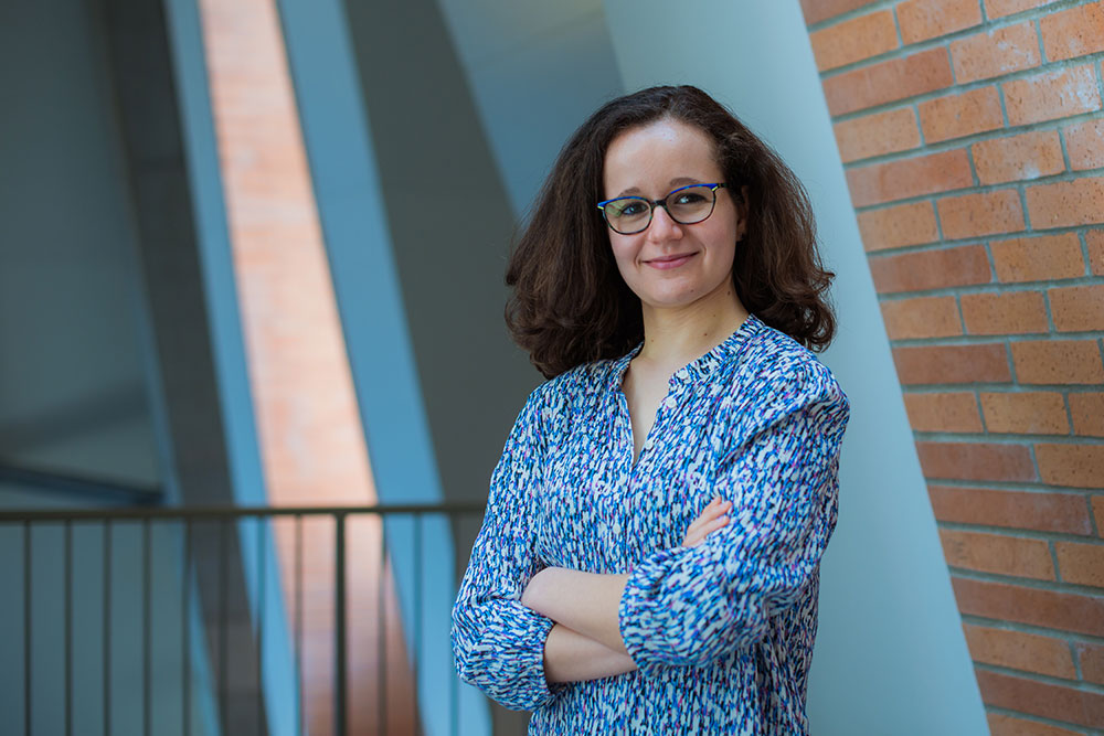 Person with arms crossed standing on the right side of the photo inside a building at MIT