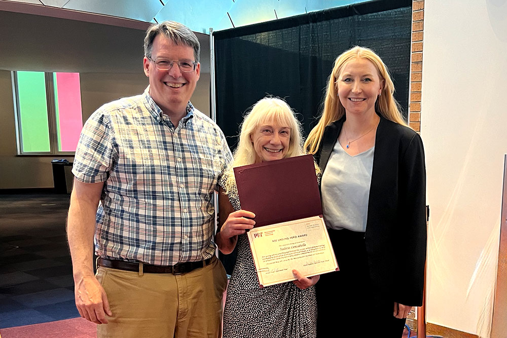 Valerie Censabella in the center holding an award certificate standing with Peter Brenton to the left and Anne White to the right, MIT